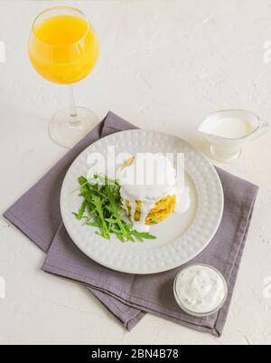 Healthy diet food concept. Tasty vegetable cutlet from carrot, zucchini, corn and pea with white sauce and glass of orange juice. Stock Photo
