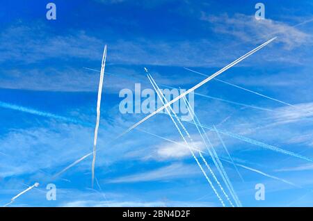 some crossing condensation trails of airplanes on a blue sky Stock Photo