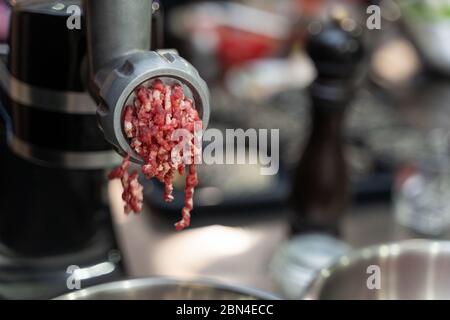 Minced beef meat coming out of a grinder Stock Photo