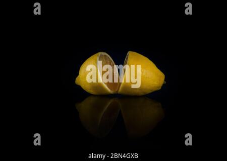 two halves of whole lemon on a black background Stock Photo