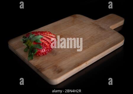 sliced strawberry on a wooden board with a place for text and a black background Stock Photo