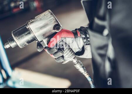 Close Up Of Car Mechanic Holding Air Impact Wrench Pneumatic Gun. Stock Photo