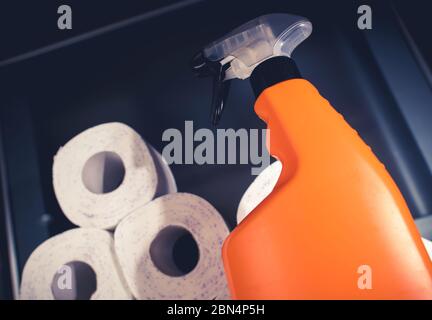View From Above Of Blue Container Filled With Rolls Of Paper Towels And Orange Spray Bottle With Liquid Cleaner. Stock Photo