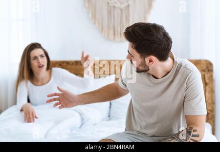 Quarrel in bed. Young couple passionately finds out relationship Stock Photo