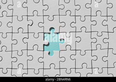 Background of white puzzle with missing piece. Top view Stock Photo
