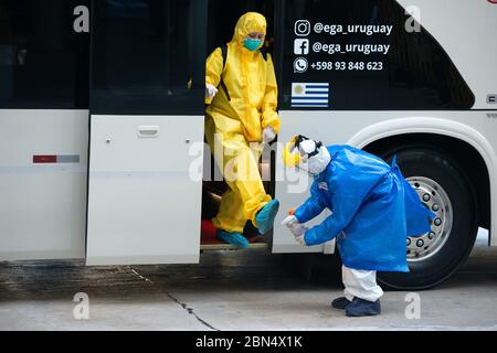 Montevideo, Uruguay. 12th May, 2020. An employee of the crew of the Australian cruise ship 'Greg Mortimer' was disinfecting her shoes when she was taken off the Regency Way Hotel gets off the bus. The crew of the 'Greg Mortimer', which had numerous coronavirus-infected people on board and was anchored in Montevideo since the end of March, has gone ashore. The crew was taken to two hotels. In April, more than 100 passengers had already been flown from the Uruguayan capital to the Australian city of Melbourne. Credit: S. Mazzarovich/dpa/Alamy Live News Stock Photo