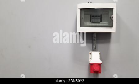 Three-phase 380 V high-voltage plug on a gray wall in a room with copy space Stock Photo