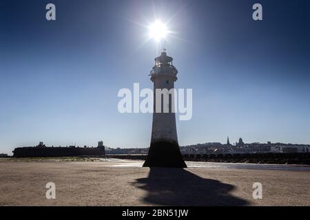 Sun rising above Perch Rock Lighthouse, New Brighton, Wirral. Stock Photo