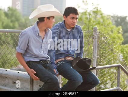 Austin Texas USA, March 2012: Hispanic teenage boys with cowboy hats talk while waiting for parade in downtown.  ©Marjorie Kamys Cotera/Daemmrich Photography Stock Photo