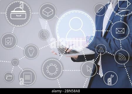 Modern technologies concept. Collage with man using laptop and different functional icons on imaginary screen, closeup Stock Photo