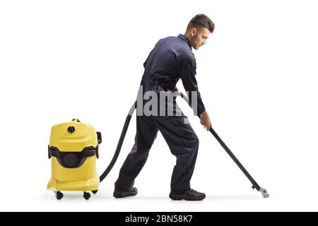 Full length shot of a janitor in a uniform cleaning the floor with a vacuum cleaner isolated on white background Stock Photo