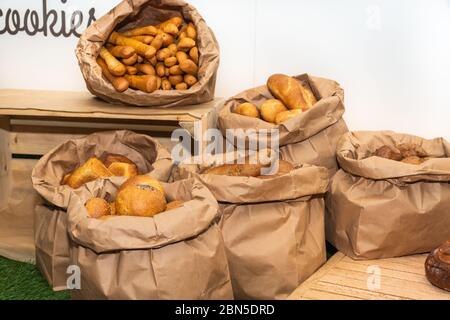 Selection of Fresh baked bread baskets and paper bags with bread roasted in the oven, croissants, baguettes, whole integral bread and pastry, rustic w Stock Photo