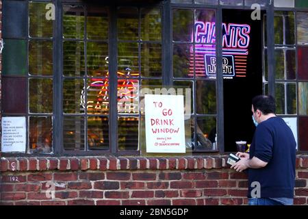 A 'To Go' drink window at 7B, Vazacs Horseshoe Bar in the East Village neighborhood of Manhattan. Due to the coronavirus COVID-19 crisis, the New York Stock Photo