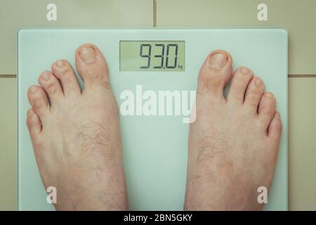 Top down view of a person standing on bathroom scales Stock Photo