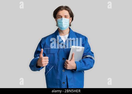 Coronavirus Protection At Work. Civil Ingineer In Medical Mask With Digital Tablet Stock Photo