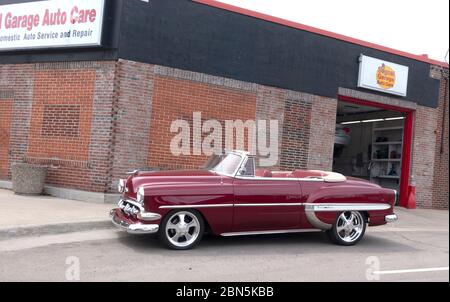 Beautiful maroon Chevrolet Bel Air convertible collectable circa 1954 parked on the street beside the Signal Garage. St Paul Minnesota MN USA Stock Photo