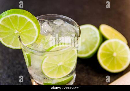 Caipirinha, traditional Brazilian alcoholic drink, typical drink made with sugar, lemon, distilled cane (cachaca) and ice. Ingredients and the drink o Stock Photo