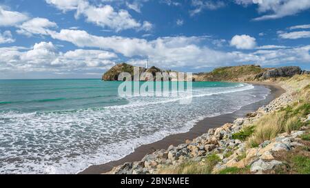 Beach with turquoise sea, in the back lighthouse of Castlepoint, Masterton, Wellington, New Zealand Stock Photo