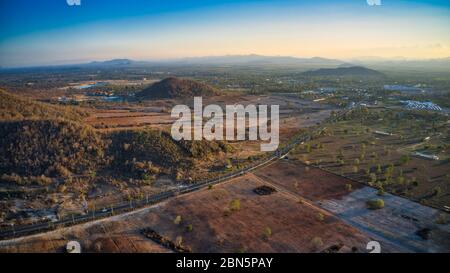 This unique photo shows the back landscape of Hua Hin in Thailand at sunset with a great sky. in the foreground the country road! Stock Photo