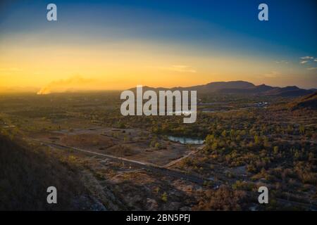 This unique photo shows the landscape of Hua Hin! In the foreground a country road and lake. In the background you can see the hills and the sunset Stock Photo