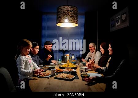 Rotterdam, Netherlands. 13th May, 2020. A family at the table having the iftar meal after sunset during the Islamic fasting month of Ramadan, the holiest month on the Islamic calendar. Credit: SOPA Images Limited/Alamy Live News Stock Photo
