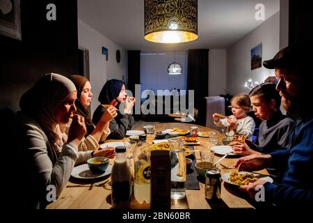 Rotterdam, Netherlands. 13th May, 2020. A family at the table having the iftar meal after sunset during the Islamic fasting month of Ramadan, the holiest month on the Islamic calendar. Credit: SOPA Images Limited/Alamy Live News Stock Photo