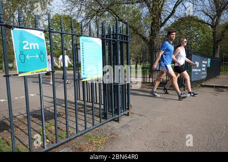 Signs on the gates reminding people to 'social-distance' at Victoria Park in east London. Park rangers and security will 'step in' if social distancing measures are ignored at open spaces, the boss of London's Olympic Park has warned as restrictions on outdoor activities are eased. Stock Photo