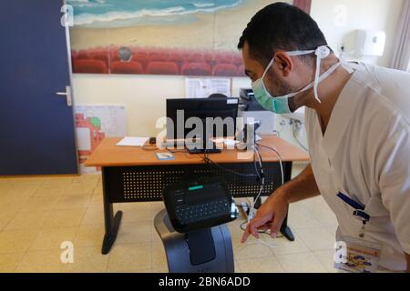 Tel Aviv, Israel. 12th May, 2020. An Israeli medical worker tests a Temi robot at Sheba Medical Center near Tel Aviv, Israel, on May 12, 2020. Temi robot, developed by an Israeli company, is being used in hospitals and medical centers to help minimize human-to-human contact amid the COVID-19 outbreak. Credit: Gil Cohen Magen/Xinhua/Alamy Live News Stock Photo