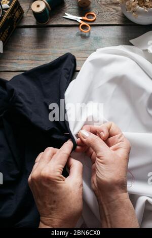 Female hands sewing with different accessories on wooden table Stock Photo