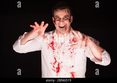Man with a crazy horror make up over black background for halloween. Stock Photo