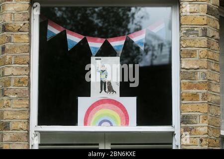 WIMBLEDON LONDON, 13 May 2020. UK. Coronavirus Lockdown.  Children's rainbow drawings  decorating a house window in Wimbledon as a show of support for the NHS (National Health Service) and all essential workers during the Coronavirus pandemic lockdown. Credit: amer ghazzal/Alamy Live News
