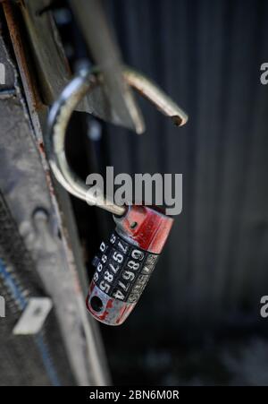 Shallow depth of field (selective focus) image with an open old cipher padlock. Stock Photo