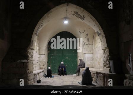 Palestinian women perform the Taraweeh prayer during the Muslim holy month of Ramadan outside the closed door of Bab al-Aa'tam or Gate of Darkness, known by a variety of names such as Gate of al-Dawadariya, Bab al-Malik Faisal or King Faisal Gate one of the three gates located on the north side of the Temple Mount leading to al-Aqsa Mosque compound in the old city of Jerusalem in Israel Stock Photo