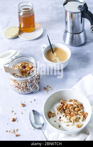 Breakfast scene with homemade granola, yogurt, honey and coffee Stock Photo