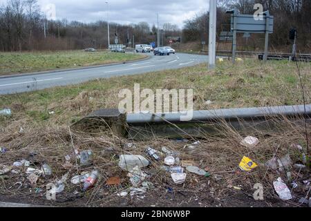 Rubbish on a roadside, thrown out of cars. Wigan, Lancashire, UK. Stock Photo