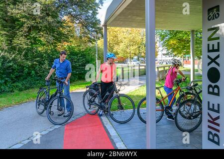 Good-humoured family uses an exemplary bicycle parking concept for a city stroll on foot Stock Photo