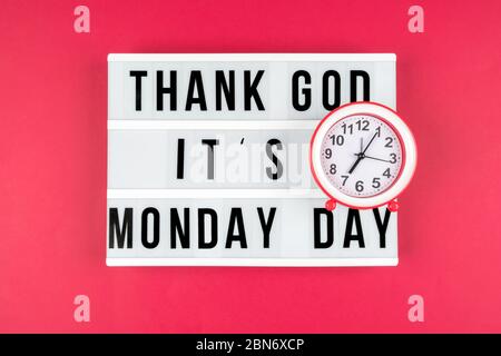 Lightbox on a red background, text Thank you God it's Monday day and alarm clock Stock Photo