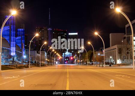 Empty Princes' Boulevard in downtown Toronto, the Enercare Centre and Princes’ Gates in purple light for helping during the COVID-19 pandemic. Stock Photo