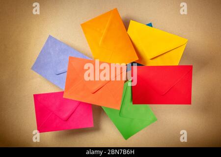 C6 envelopes flying over a brown kraft paper background, of various colors Stock Photo