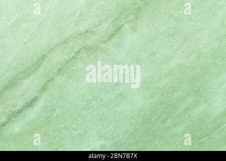 Texture of light green marble with olive lines of a pattern, macro background. Pastel color stone backdrop from mineral tile, closeup. Stock Photo