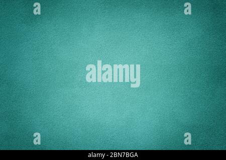 turquoise matte background of suede fabric, closeup. Velvet texture of seamless cyan leather. Felt material with vignette. Stock Photo