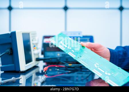 Debugging electronics device. PCB witch microcontroller in electronics laboratory Stock Photo