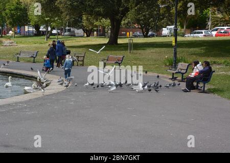 People enjoying sitting in the park at Canoe Lake, Southsea, Hampshire, after the lifting of coronavirus lockdown restrictions on some leisure activities - including tennis, water sports, angling and golf. Stock Photo