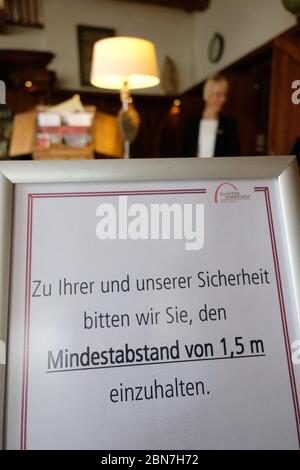 Grimma, Germany. 13th May, 2020. A sign saying 'For your and our safety, we ask you to keep a minimum distance of 1.5 m.' will be placed at the reception of Hotel Kloster Nimbschen before the forthcoming reopening. The rules for catering businesses in Saxony will be further relaxed from 15.05.2020. Credit: Sebastian Willnow/dpa-Zentralbild/dpa/Alamy Live News Stock Photo