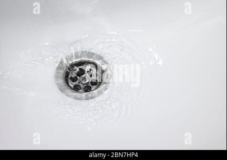 water flow into drain in bath Stock Photo