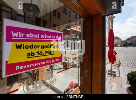 Dresden, Germany. 13th May, 2020. A sign with the inscription 'We are back!' is stuck on the door of a restaurant on Neumarkt. Under strict hygiene conditions, restaurants in the Free State are allowed to reopen from 15 May. Credit: Robert Michael/dpa-Zentralbild/dpa/Alamy Live News Stock Photo