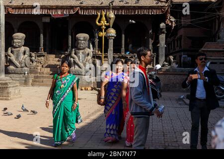 Bhaktapur, Nepal - November 15, 2016: Nepalese people in beautiful clothes walk around the Dattatreya square. Stock Photo