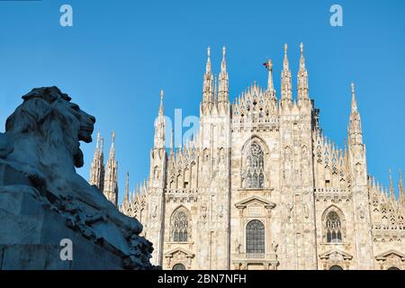 The golden sunshine is reflecting on the front of the magnificent Duomo di Milano or Milan Cathedral after Italy eases coronavirus restrictions after Stock Photo