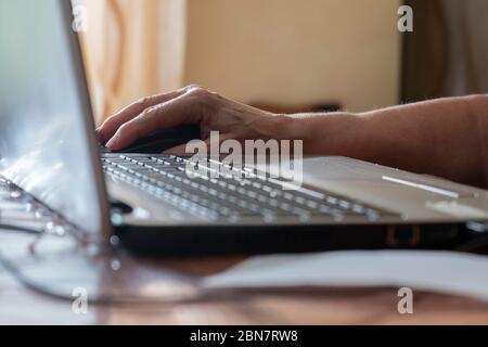 Hand of elderly woman using the notebook. Focus on hand. Concept of computer use by older people. Stock Photo