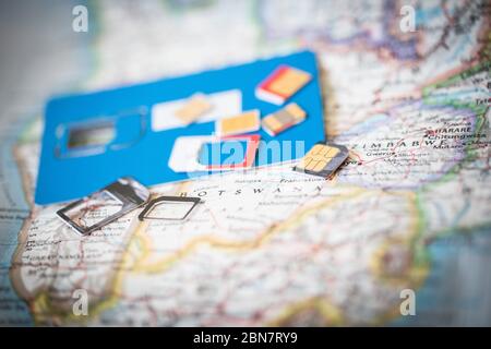 Close up of sim cards on a map; travellers can trade out sim cards by country to stay in communication while keeping costs low. Stock Photo